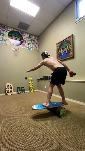 Guy Balances Himself on Balance Board and Throws Balls in Basket - 1291009