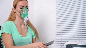 Sick woman with sore throat makes inhalation with mask on his face. Sick patient heals itself nebulizer. Covid treatment.