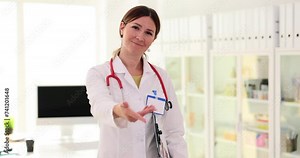 Smiling female doctor offering helping hand in clinic