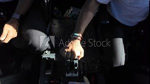 A closeup view inside a jet cockpit of two pilot preparing for landing and operating the thrust levers ( chopped point of view). 4K