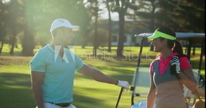 Happy couple interacting with each other while playing golf at golf course 4k