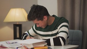 Happy young man writing with pen and paper - Free Stock Video
