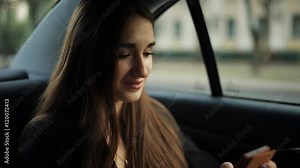 Beautiful business woman traveling in a taxi to an important meeting and corresponding with colleagues using a smartphone Stock Video