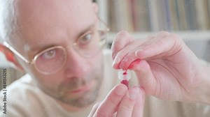 man pricking finger and collecting blood in tube for self-administered medical rapid test, Personal health data, closeup fingers and action