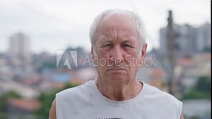 Aged and wrinkled old caucasian man pensioner standing on the street. Tired and sad elderly senior. Grandfather. Blurred background. Portraits.