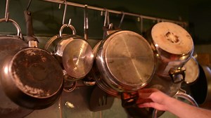 Download Many Pans in the Kitchen, a Man takes a Pan for Cooking for free