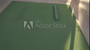 This video shows a golf ball bouncing off wall and scoring a hole in one win.