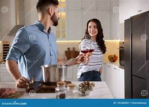 Lovely Couple Drinking Wine While Cooking Together At Kitchen Stock