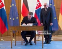 Slovakian Prime Minister Robert Fico signs the guestbook, with German ...