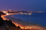 the beach is lit up at night with lights on