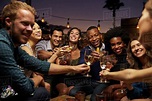 Group of friends enjoying night out at rooftop bar - Stock Photo - Dissolve