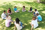 Amigos sentados en un círculo en el parque | Foto Premium