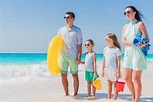 Happy beautiful family on a tropical beach vacation going to swim ...
