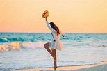 Mujer hermosa joven en la playa tropical en puesta de sol. | Foto Premium