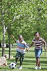 African American children playing soccer in park - Stock Photo - Dissolve