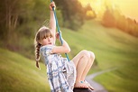 Little girl is playing on a swing in the nature free image download