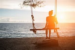 Premium Photo | Young woman watching sunset alone sitting on swings on ...