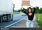 Young woman hitchhiker on road Stock Photo by ©AY_PHOTO 172676624