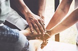 Group of business people putting their hands working together on wooden ...