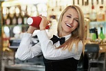 Young female bartender using cocktail shaker - Stock Photo - Dissolve