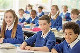 Elementary school children smiling in classroom - Stock Photo - Dissolve
