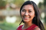 Portrait of a beautiful young Filipino woman smiling in a city park in ...