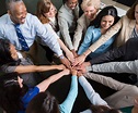 Diverse team of professionals with hands in teamwork huddle - GMS ...