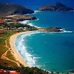 an aerial view of the beach and ocean with mountains in the background ...