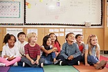Elementary school kids sitting on classroom floor - Stock Photo - Dissolve