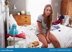Woman Sitting On Edge Of Bed