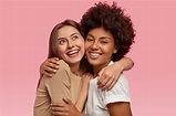 Foto de duas mulheres alegres se abraçando e sorrindo positivamente ...