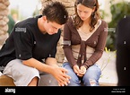 Two teens praying together Stock Photo - Alamy