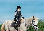 Boy horseback riding at ranch - Stock Photo - Dissolve