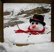 This framed image is a picturesque capture of a snowman melting as the ...