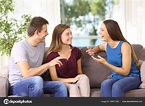 Tres amigos alegres hablando en un sofá en casa: fotografía de stock ...