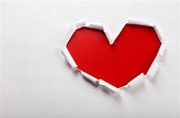 Corazón de papel rasgado blanco sobre fondo rojo. | Foto Premium