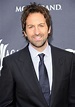 a man in a suit and tie smiling for the camera at an awards event with ...