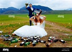 drunken bride with lots of empty beer bottles in mountain landscape and ...