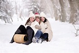 Three Women Sitting on Snow Covered Ground during Day · Free Stock Photo