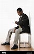 Young man sitting waiting Stock Photo - Alamy