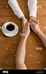 A couple holding hands across a table Stock Photo - Alamy