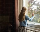 Girl looking out window stock photo