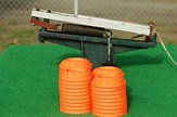 Clay pigeons stacked next to a portable trap thrower mounted on - The ...