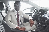 Stylish black businessman sitting behind the wheel of new luxury car ...