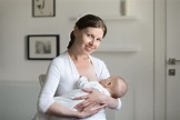 Portrait of a young smiling attractive woman breastfeeding a chi ⋆ ...