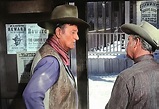 In Rio Lobo (1970), John Wayne’s character stands next to a Wanted ...