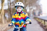 Kid Boy in Safety Helmet and Colorful Raincoat Riding Bike, Outd Stock ...