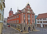 an orange and white building with two clocks on it's sides in front of ...
