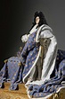 a statue of a man dressed in blue and gold with a white cloak on his head