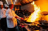 Cocinero Que Cocina La Comida China Con El Fuego Ardiente En La ...